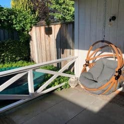 Houten Hangstoel in ei-vorm onder de veranda