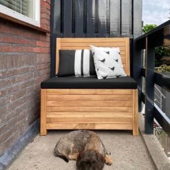 Balkonbank 85 cm breed - Met opbergruimte - Duurzaam Teakhout - Kleine tuinbank voor balkon, veranda of kleine tuin - 85 x 65 x 90 cm Het balkonbankje van 85 cm breed op een balkon van 90 cm breed. Zwart kussen.